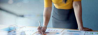 woman working over printed graphs on a table
